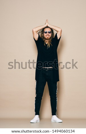  A man in dark clothes on a light background in full growth fashion style party disco party                              
