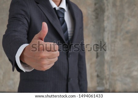 Businessman showing thumbs up sign.thumbs-up is a sign that you make by raising your thumb for showing that you happy with idea or situation,agree with someone or everything is all right