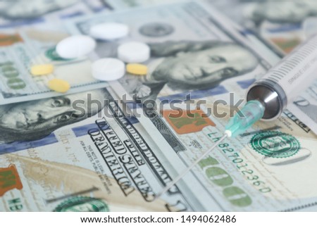 medicine pill and syringe on 100 dollar banknote background.Healthcare insurance and medical treatment cost concept