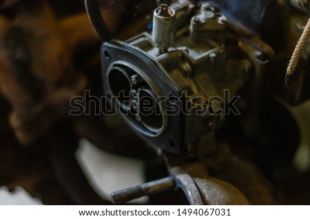 Old disassembled gasoline carburetor. Spare four-stroke gasoline engine. Close-up. Soft focus. The horizontal location of the picture.