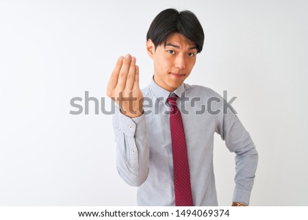 Chinese businessman wearing elegant tie standing over isolated white background Doing Italian gesture with hand and fingers confident expression