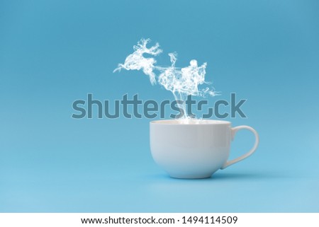 Steam in reindeer and Santa Claus into sled shape flying from coffee cup. Morning drink. Christmas or New Year celebration concept. Copy space.