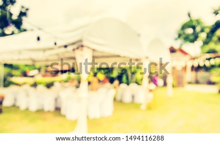 Vintage tone abstract blur image of Banqueting table decoration at outdoor party with bokeh for background usage .