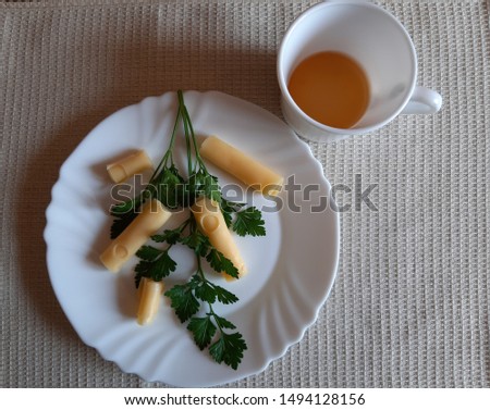On a white plate is eden cheese with green parsley.