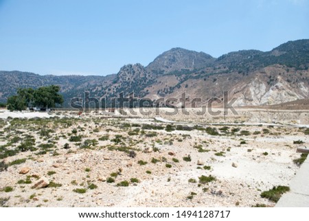 Greece, Nisyros island. Road to the crater of volcano. Man in orange clothes in the distance