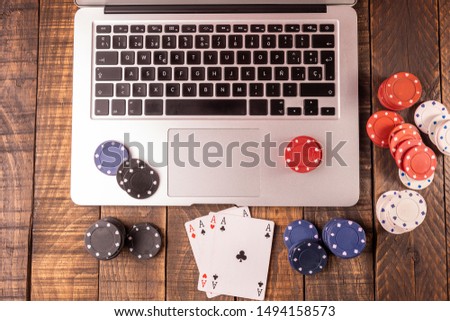 Online betting or poker. Top view of a computer with chips and cards for betting or playing. Online game concept. Royalty-Free Stock Photo #1494158573