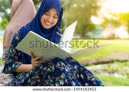Teenager Young Adult Asian Thai Muslim university college student reading book together using for education concept