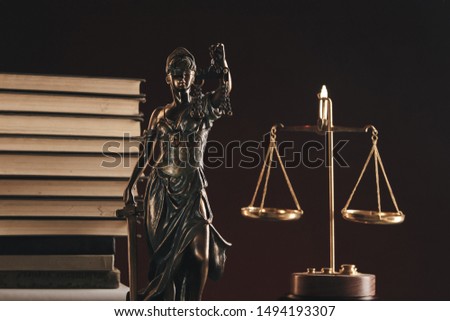 Attorney and notary concept. Books standing behind statue of justice.