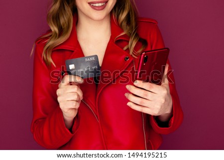 Picture of lovely lady holding credit card and mobile in a studio.
