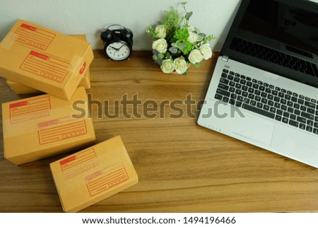 Laptop computer and Product Box or shipping parcel box on wooden table, Online shopping, work at home, e commerce