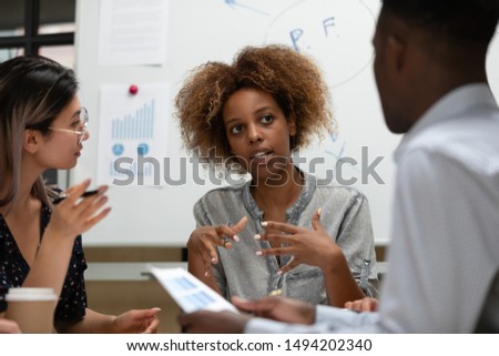 Serious female african leader manager talking during group office briefing teaching multiracial corporate business team explain coworkers clients project plan discuss company strategy at meeting Royalty-Free Stock Photo #1494202340