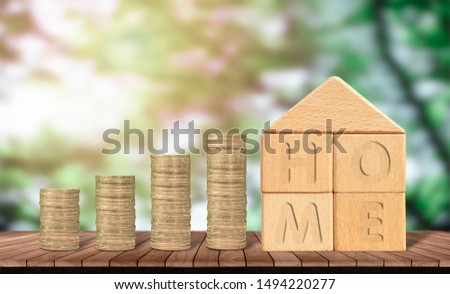 Concept of loans for hire purchase
Real estate , a pile of coins and house models on wood and tree bokeh blur background. saving money for  planned investment in the future concept.