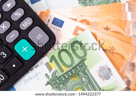Close-up of calculator on Euro banknotes. Euro money bills to pay. Finances and budget concept. Tax and money.