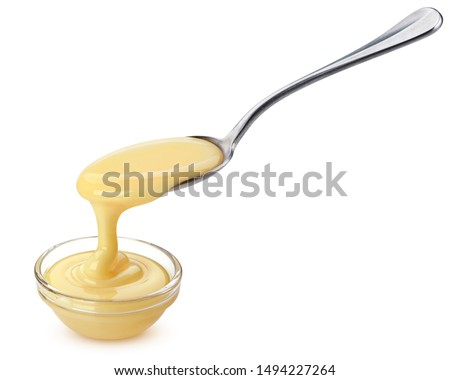 Pouring condensed milk with spoon isolated on white background with clipping path, delicious flowing creamy evaporated cream Royalty-Free Stock Photo #1494227264