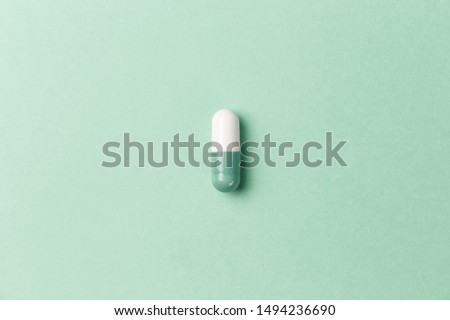 Pharmaceutical medicine pills, tablets and capsules on mint background. Top view. Flat lay. Copy space. Medicine concepts. Minimalistic abstract concept. Neo mint color Royalty-Free Stock Photo #1494236690