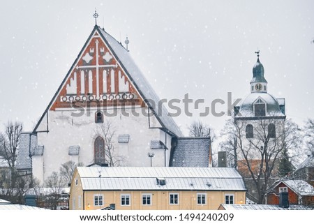 Old historic Porvoo, Finland with wooden houses and medieval stone and brick Porvoo Cathedral under white snow in winter.