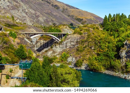 Incredible adventures in New Zealand. Old bridge over the Kamarau river. The water in the river is bright green. The concept of extreme, active and photo tourism