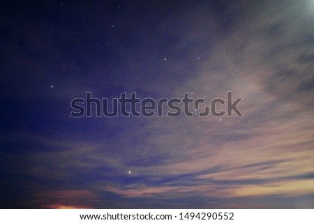 Winter starry sky with Orion constellation over lake 