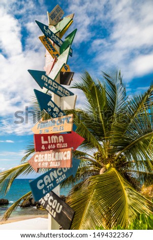 Directional sign on the beach indicating different wold destinations, photographed in Jamaica