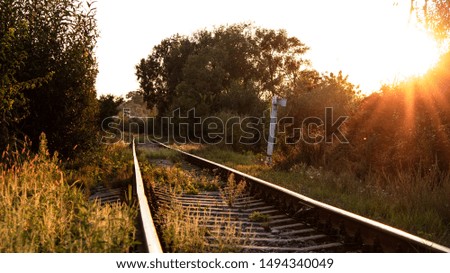 railway tracks in a rural scene with nice sunset