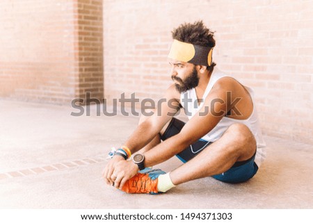Latin man stretching the muscles outdoor