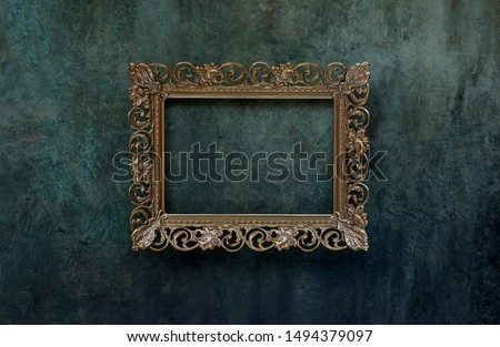Vintage openwork bronze metal frame on a old wall background