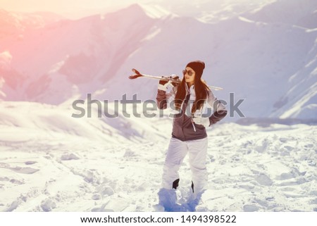 young and active brunette skiing in the snowy mountains
