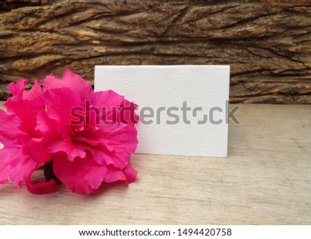 Pink Azalea with Blank Card. Floral arrangement over rustic wood.                               