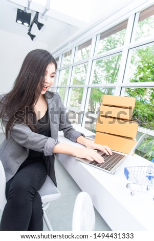 Young businesswoman holding credit card for online payment with using laptop computer at home. Online e-shopping and payment financial transactions online concept