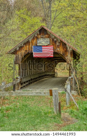 A long abandoned covered bridge still stands with its weathered wood