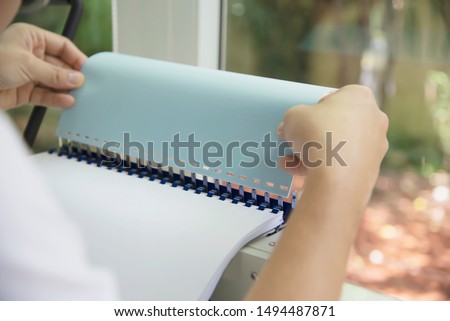 Man making report using comb binding machine - people working with stationary tools concept Royalty-Free Stock Photo #1494487871