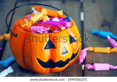 Pumpkin with candy on wood table for halloween concept.