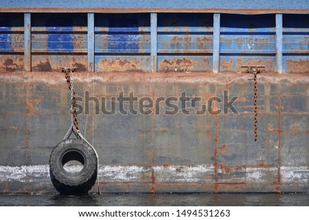 tire hanging from rusting hulk Royalty-Free Stock Photo #1494531263