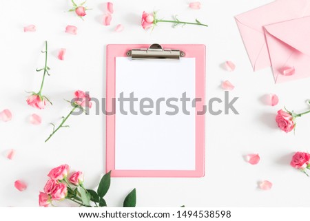Flowers composition romantic. Flowers roses and rose petals,  clipboard on white background. Happy women's day. Valentine's Day.  Flat lay, top view, copy space