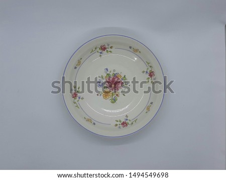 white vintage plate with floral print shot isolated from top view on white background 
