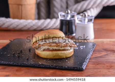 Chicken Burger Grilled Styled and Garnished on Black Board