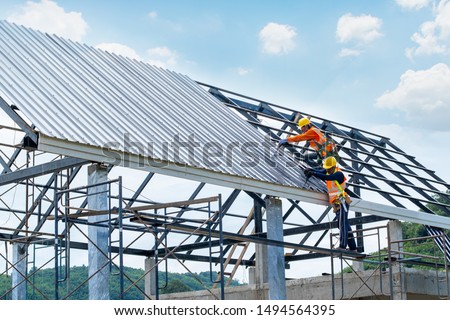 Working at height equipment.Construction worker wearing safety harness are working on the roof house in construction site. Royalty-Free Stock Photo #1494564395