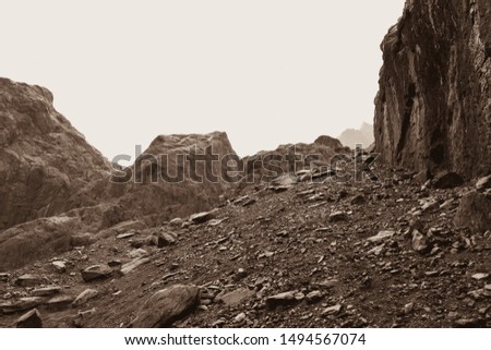 A sloping slope covered with loose stones. Difficult climb to Aktru. Beautiful views of the mountains on a tour of the nature of Altai land. Hiking and mountain climbing in the mountains. Toned sepia. Royalty-Free Stock Photo #1494567074