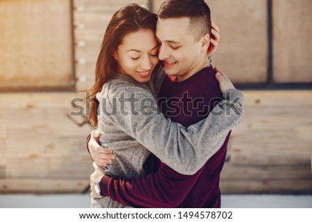 Cute couple have fun. Boy and girl in a winter park. Man in a red sweater. Brunette in a gray sweater