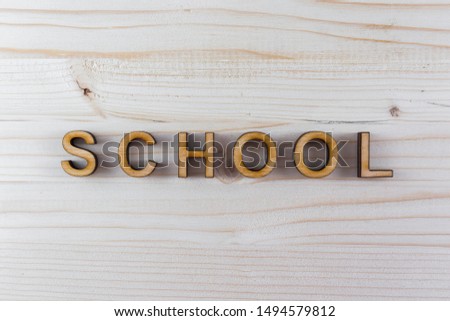 The inscription school from plywood laser-cut on wood background