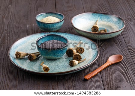 Poppy seeds and seedpods in ceramic bowl