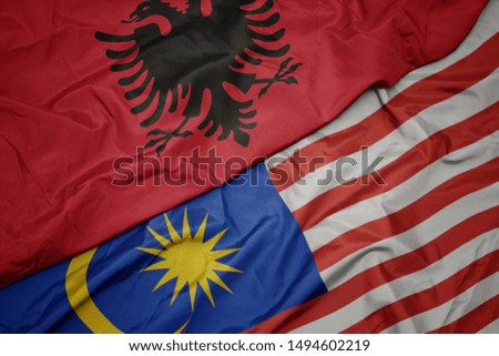 waving colorful flag of malaysia and national flag of albania. macro