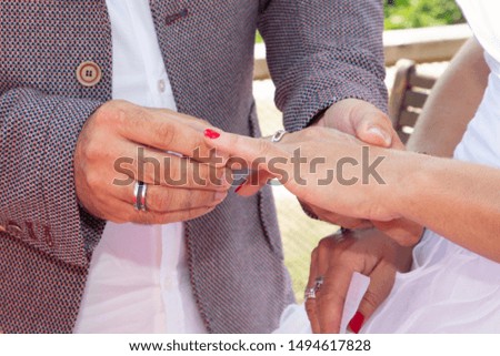 exchange of wedding rings bride and groom outdoor