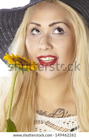 Woman with very fair hair wear summer clothes, a black hat and hold a sunflower. The person is exempted on white background.