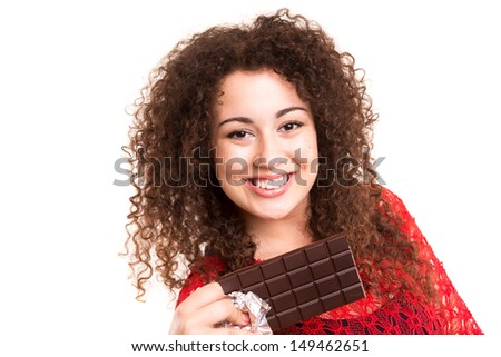 Beautiful young woman eating a chocolate bar