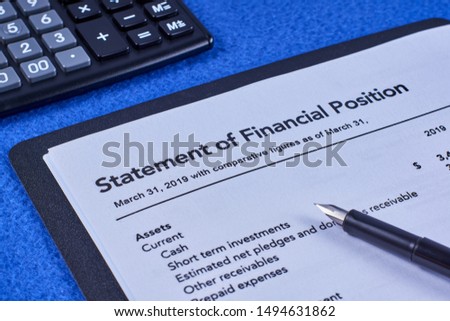 Sheet a statement of financial position in a black folder, pen and calculator on a blue velvet background Royalty-Free Stock Photo #1494631862