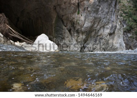 Blurred picture. Part of the magnificent Venetikos river of Portitsa Gorge, with point of the mountain to appear as a cave. Low level. The liquid is flowing at this point. Grevena, Greece.