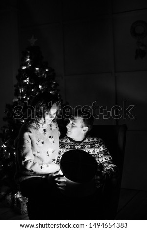 young couple in love in christmas decor with gifts and christmas tree