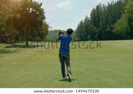 Golfer playing golf in the evening golf course, on sun set evening time. Man playing golf on a golf course in the sun.