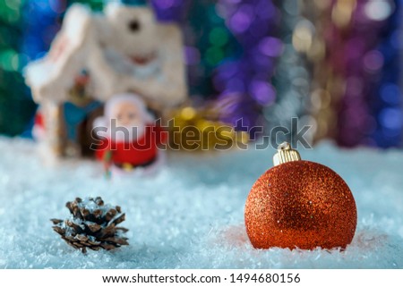 Christmas composition with a big red ball and Christmas toys on background artificial snow